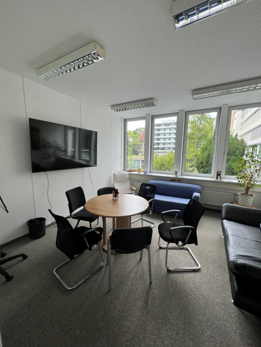 Bild eines Tagungraum der KjG Bundesstelle mit TV, Couch, Tisch und Stühle